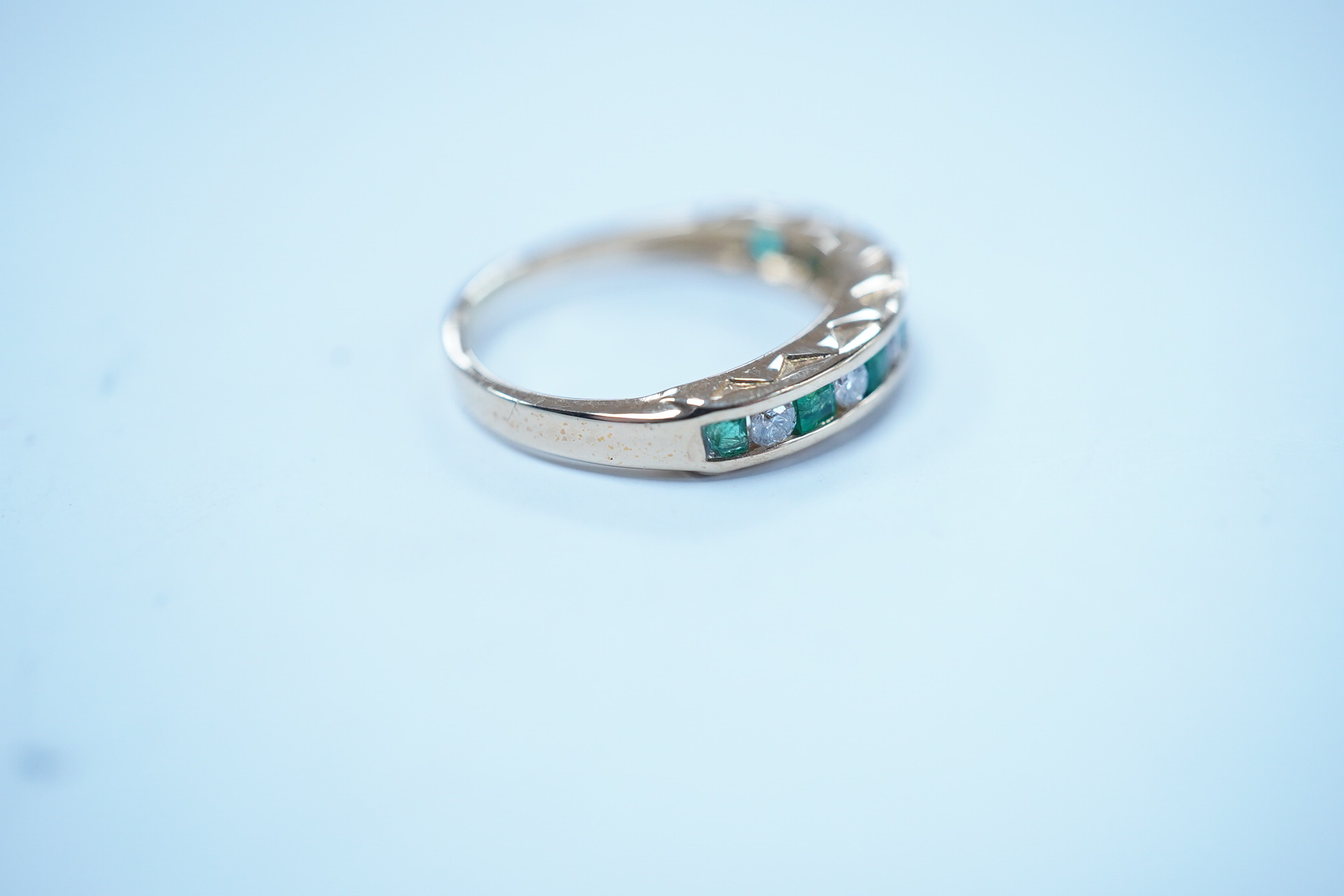 A modern 18k, seven stone emerald and six stone diamond set half hoop ring, size F/G, gross weight 2.4 grams. Condition - poor